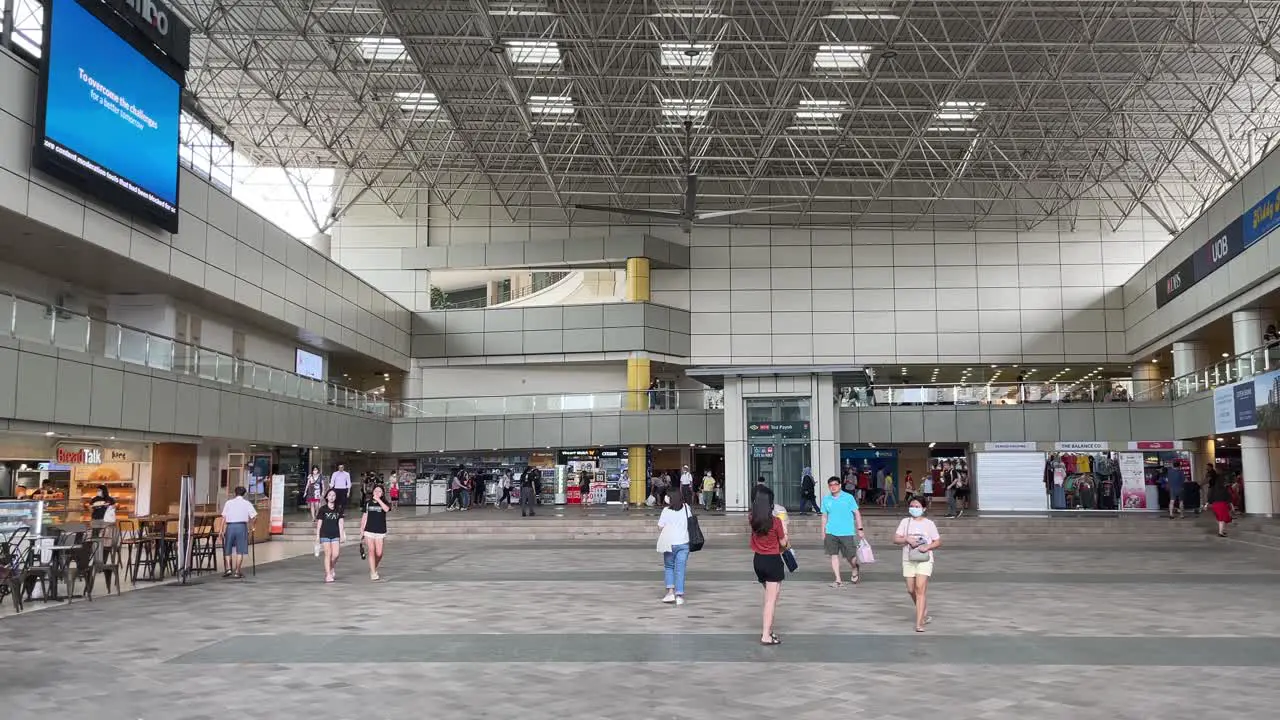 People walk around Toa Payoh Square outside bus interchange in Singapore