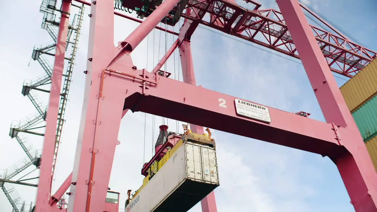 Port of Montreal heavy crane carefully loading shipping container onto haulage lorry in dockyard