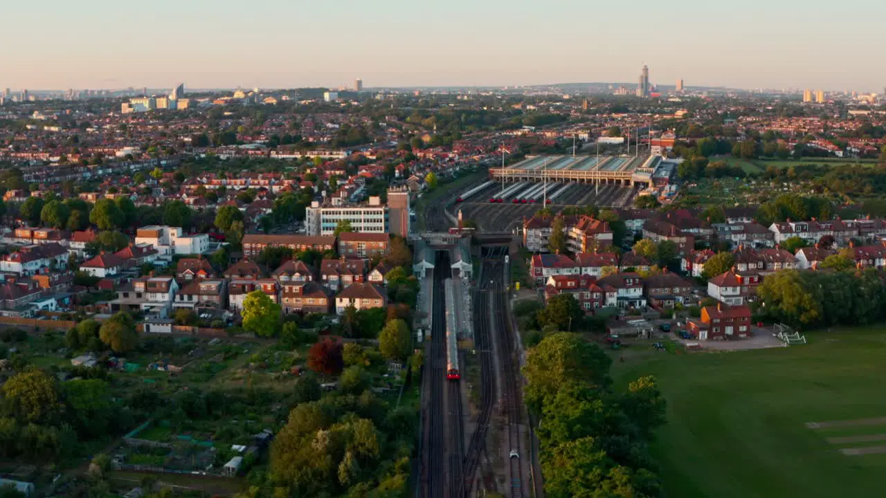 Head on reversing drone shot of London Underground piccadilly line train leaving the station