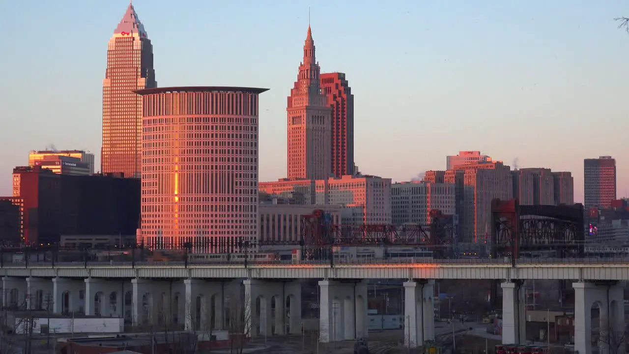 A rapid transit train moves in front of the city of Cleveland Ohio