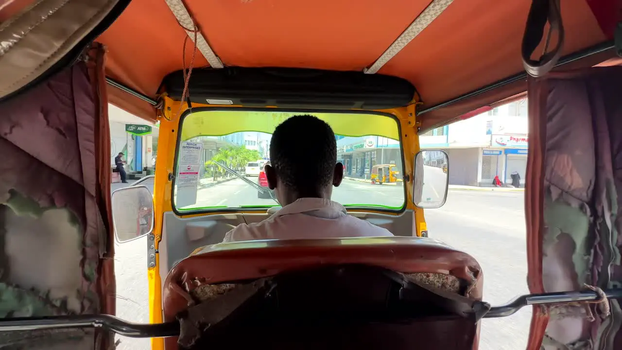 Driving through Nairobi city in Kenya in tuk tuk or rickshaw vehicle