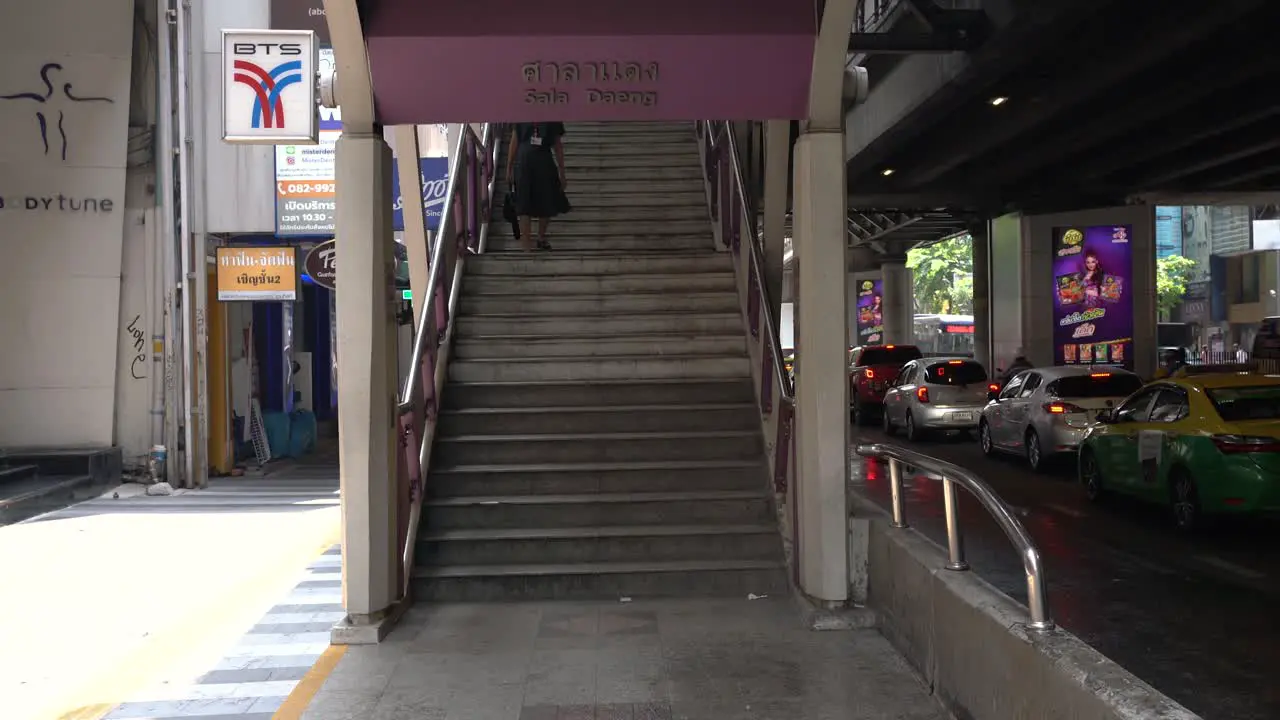 Scene of people walking past and down the stairs of Sala Daeng BTS Skytrain Station a bustling commercial and transportation hub in Silom Bangkok Thailand