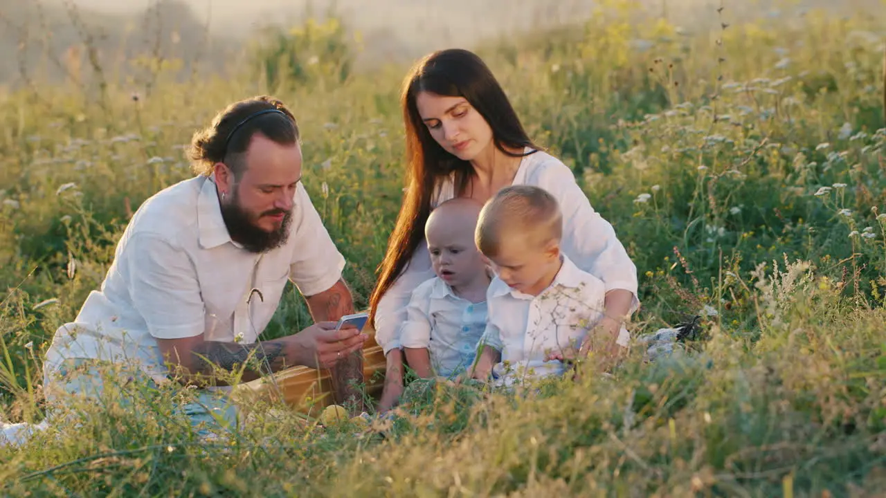 A Stylish Young Woman With Long Hair Along With A Bearded Husband And Two Small Cool Children Watchi