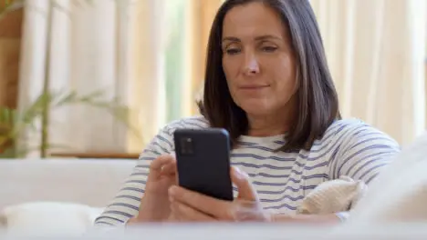 Pedestal Shot Revealing Middle Aged Woman Scrolling On Smartphone