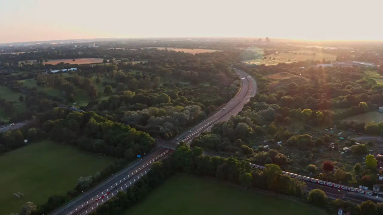 Follow drone shot of London Underground Piccadilly Line train at sunset