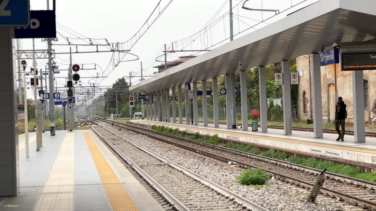 People commuting on train station platform in Bergamo city in Italy