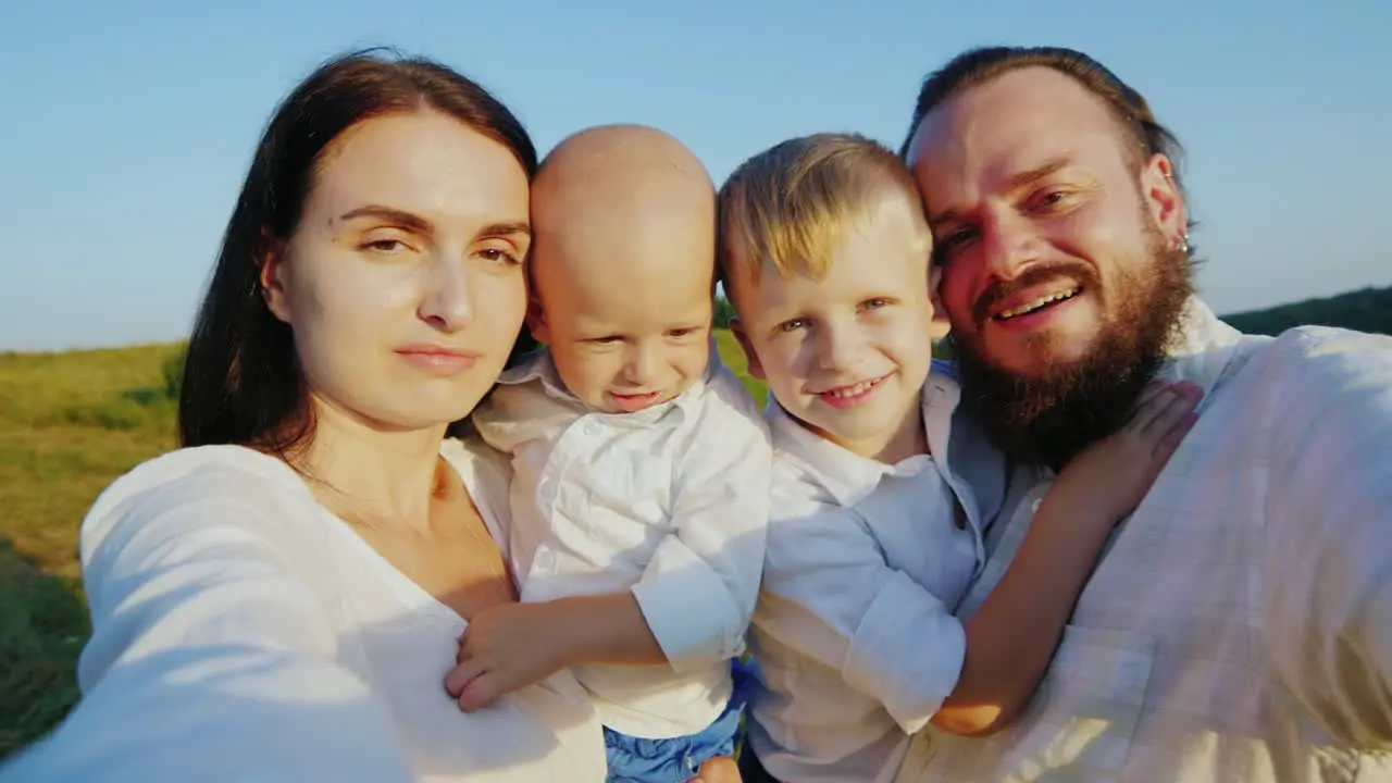 The Young Father Along With His Family Makes Selfie The Camera Moves With Them