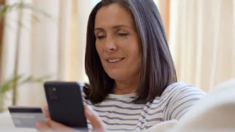 Pedestal Shot Revealing Middle Aged Woman Using Smartphone to Make Online Purchase