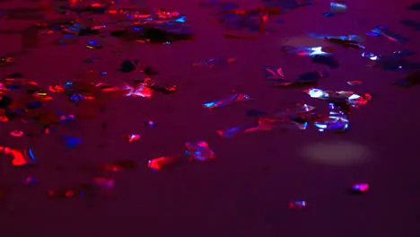 Close Up Of Sparkling Confetti On Floor Of Nightclub Bar Or Disco With Flashing Strobe Lighting