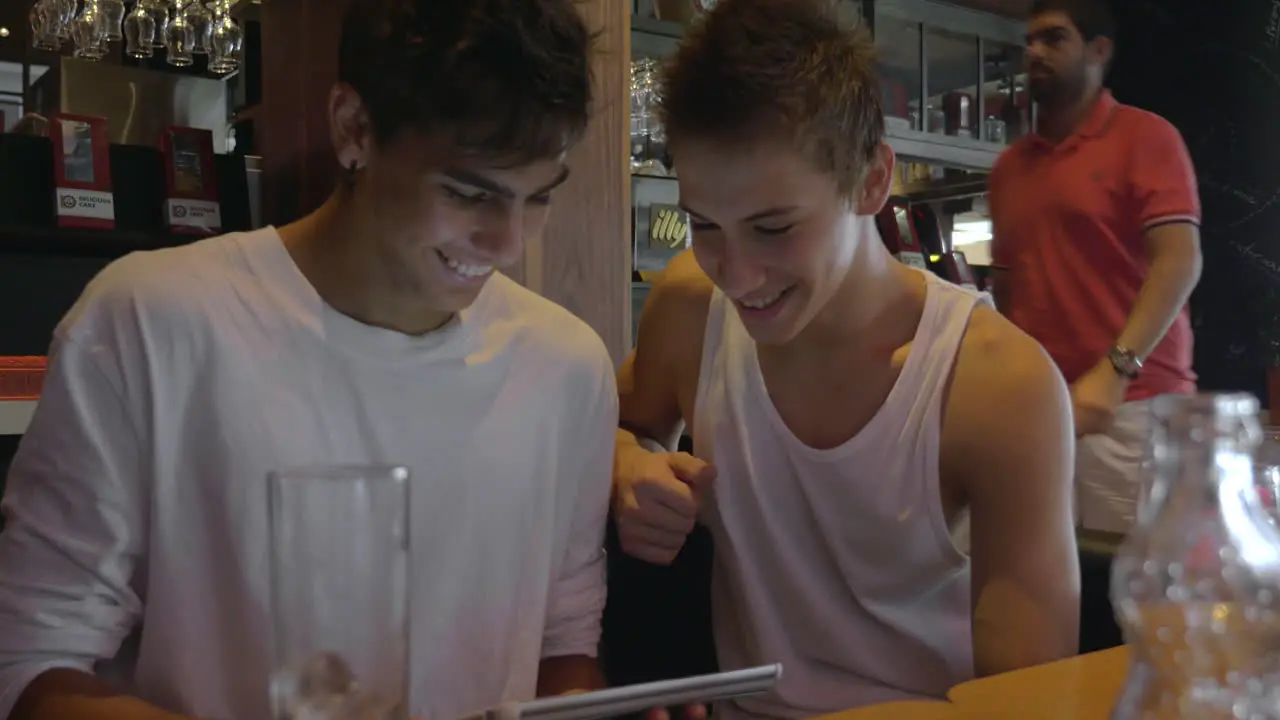 Two teenagers with pad in cafeteria