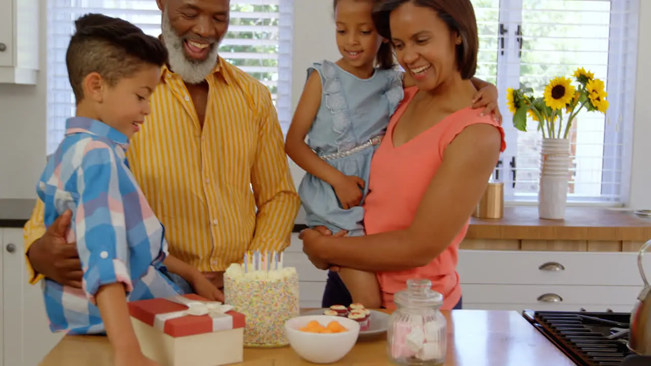 Front view of black family celebrating birthday in kitchen of comfortable home 4k