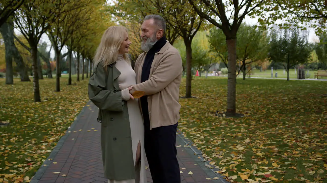 Beautiful couple having fun close up face to face in autumn park