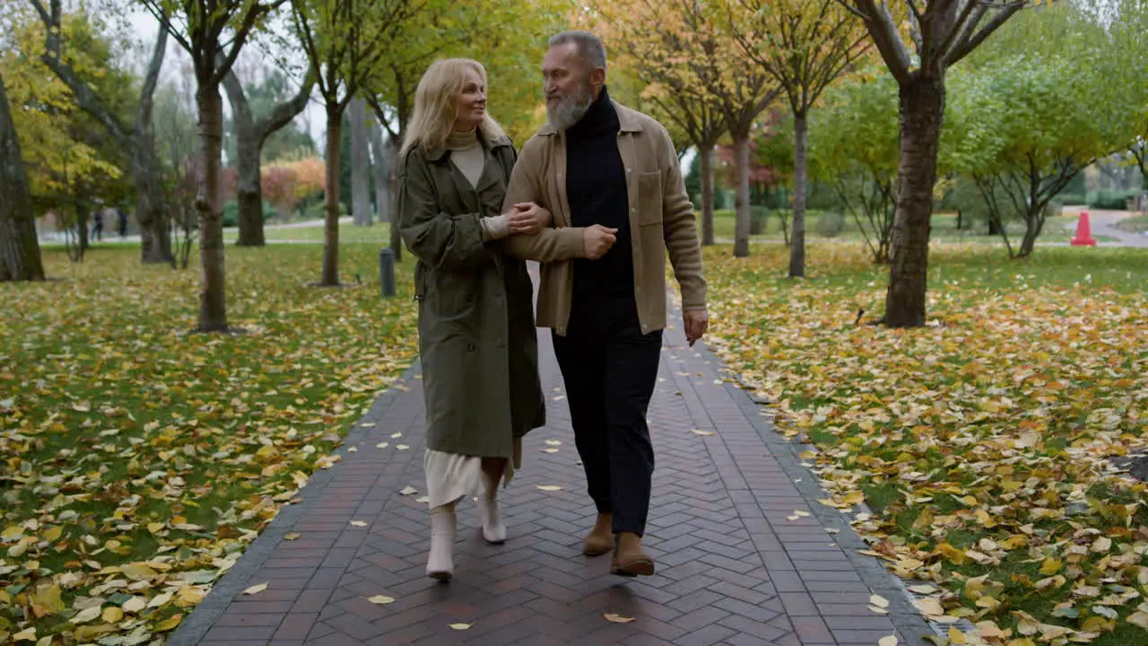 Happy senior couple walking through the park Smiling elderly family 