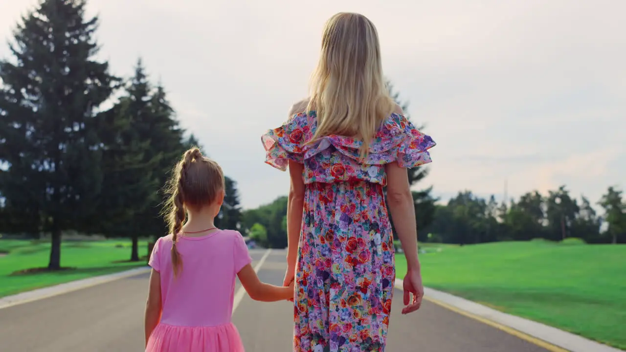 Rear view of woman and girl walking outdoor Family enjoying time in garden