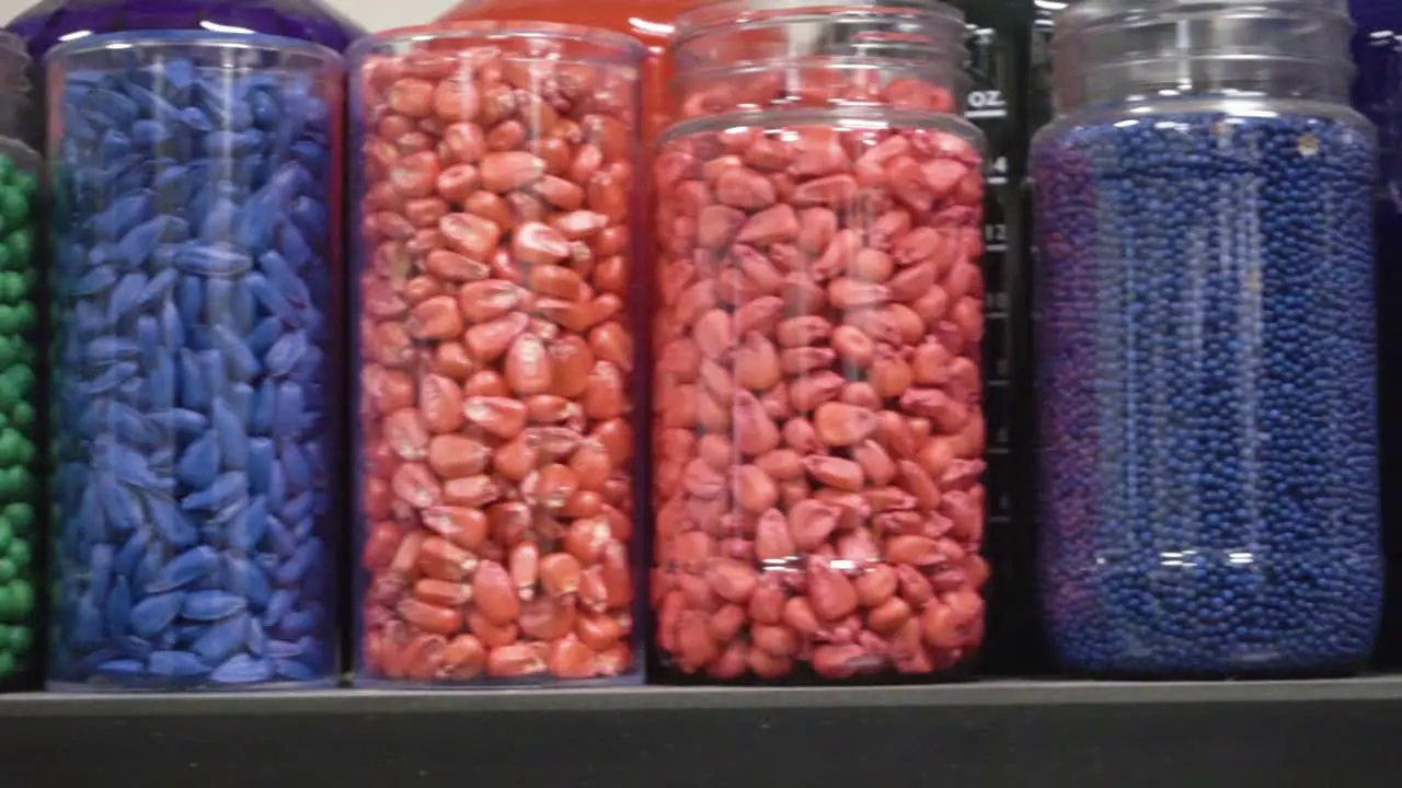 Jars of color treated soybean and corn seeds at an ag science lab