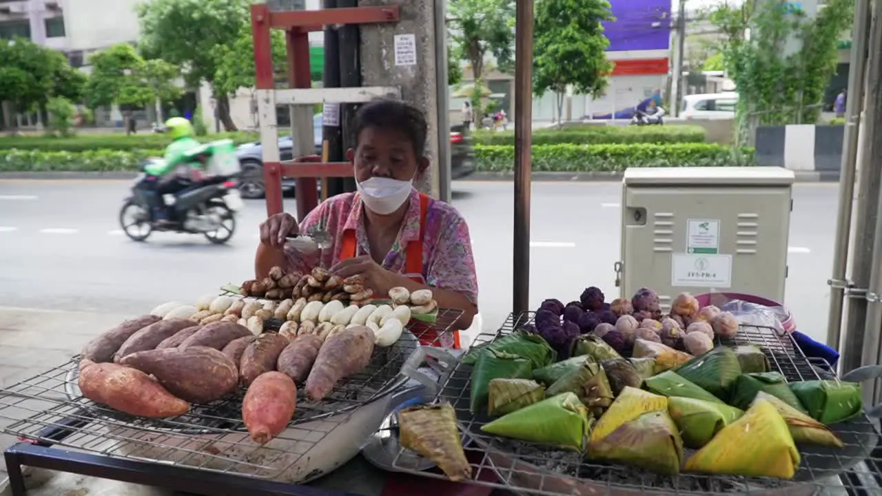 Old Asian woman preparing food on street