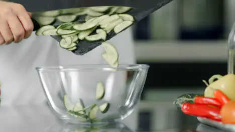 Fresh vegetables at kitchen restaurant Closeup sliced cucumber in slow motion