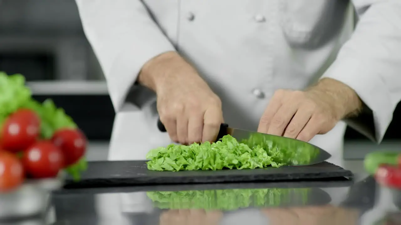 Chef hands cutting food at kitchen Closeup chef hands cutting salad with knife