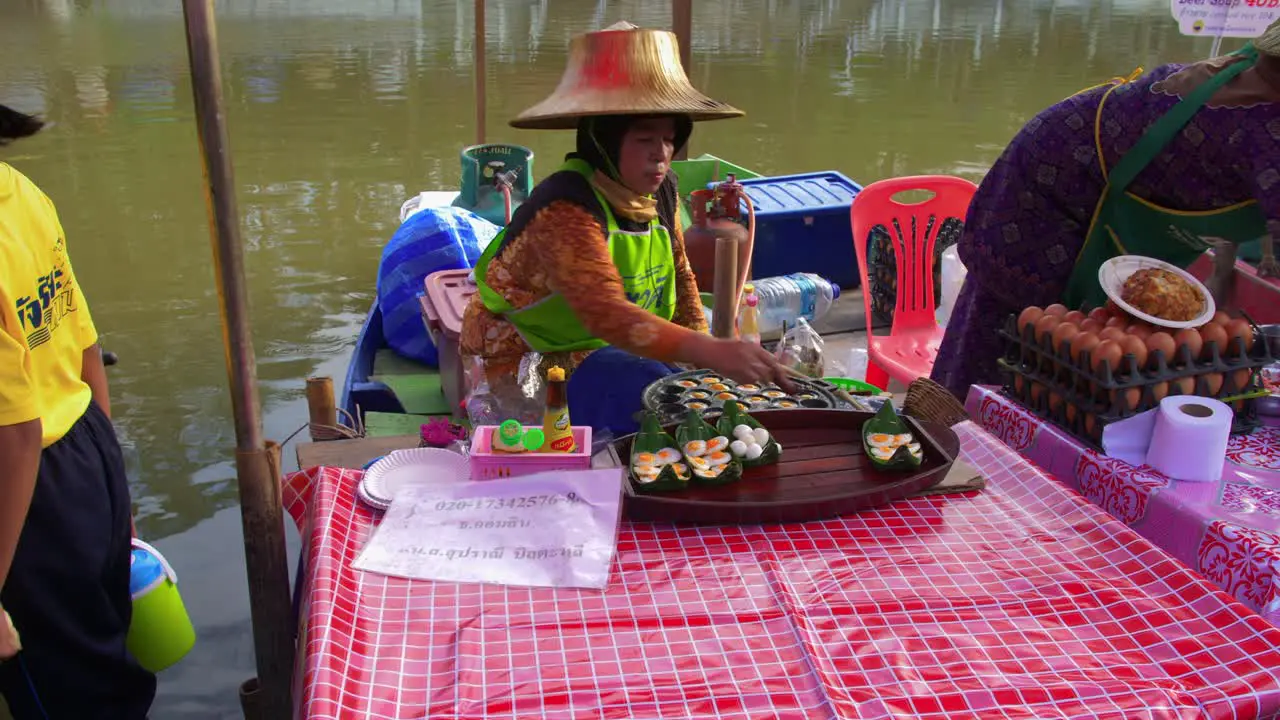 Working woman selling small quail eggs at a local street stall in a Thai outdoor market