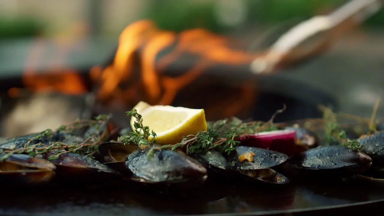 Mussels in shells preparing outside Seafood browning on grill outdoors