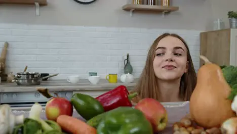 Lovely young girl spying from under the table and grabbing fresh apple and eating it Diet concept