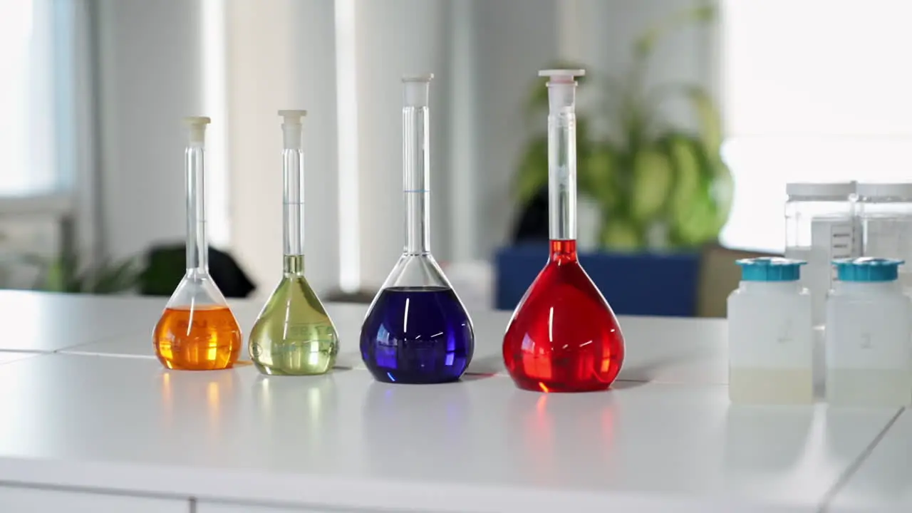 Colorful Liquids in Glass Beaker Test Tube Flasks in Scientific Chemical Laboratory Prepared for Experiments in slowmo