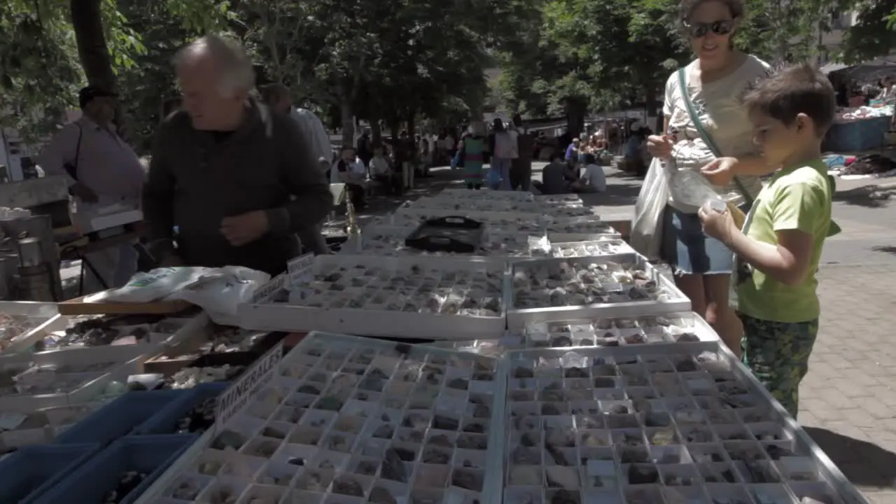 young boy choosing minerals to buy from a market stall in Madrid