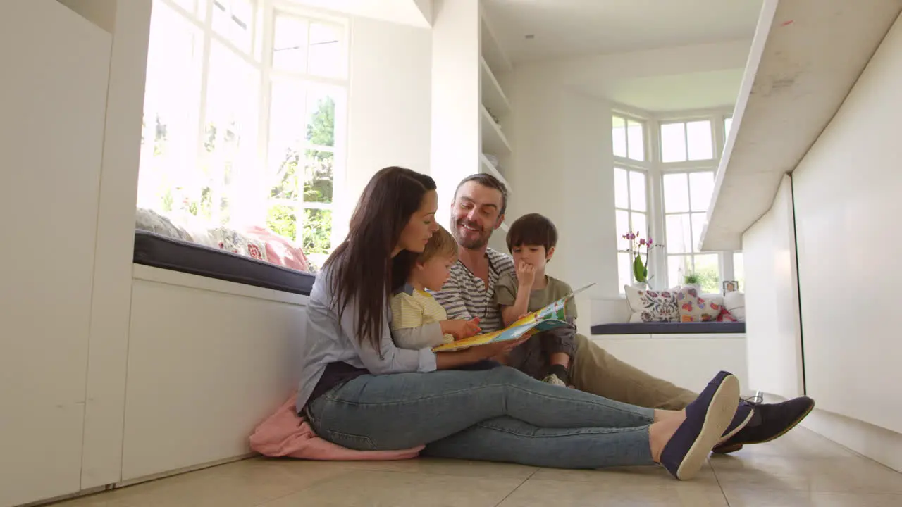 Family Sitting On Floor Reading Story At Home Shot On R3D