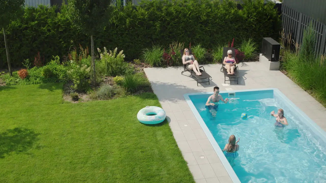 A family plays ball in the pool Having a good time on a hot summer day