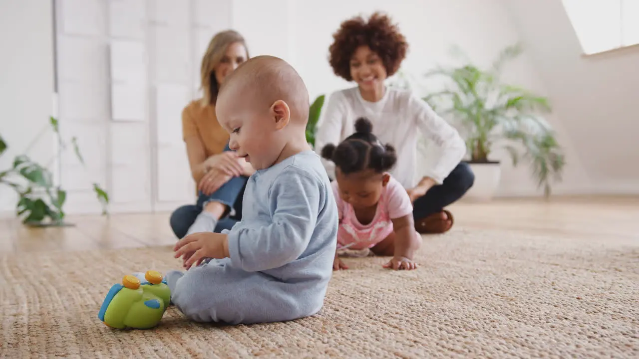 Two Mothers Meeting For Play Date With Babies At Home In Loft Apartment