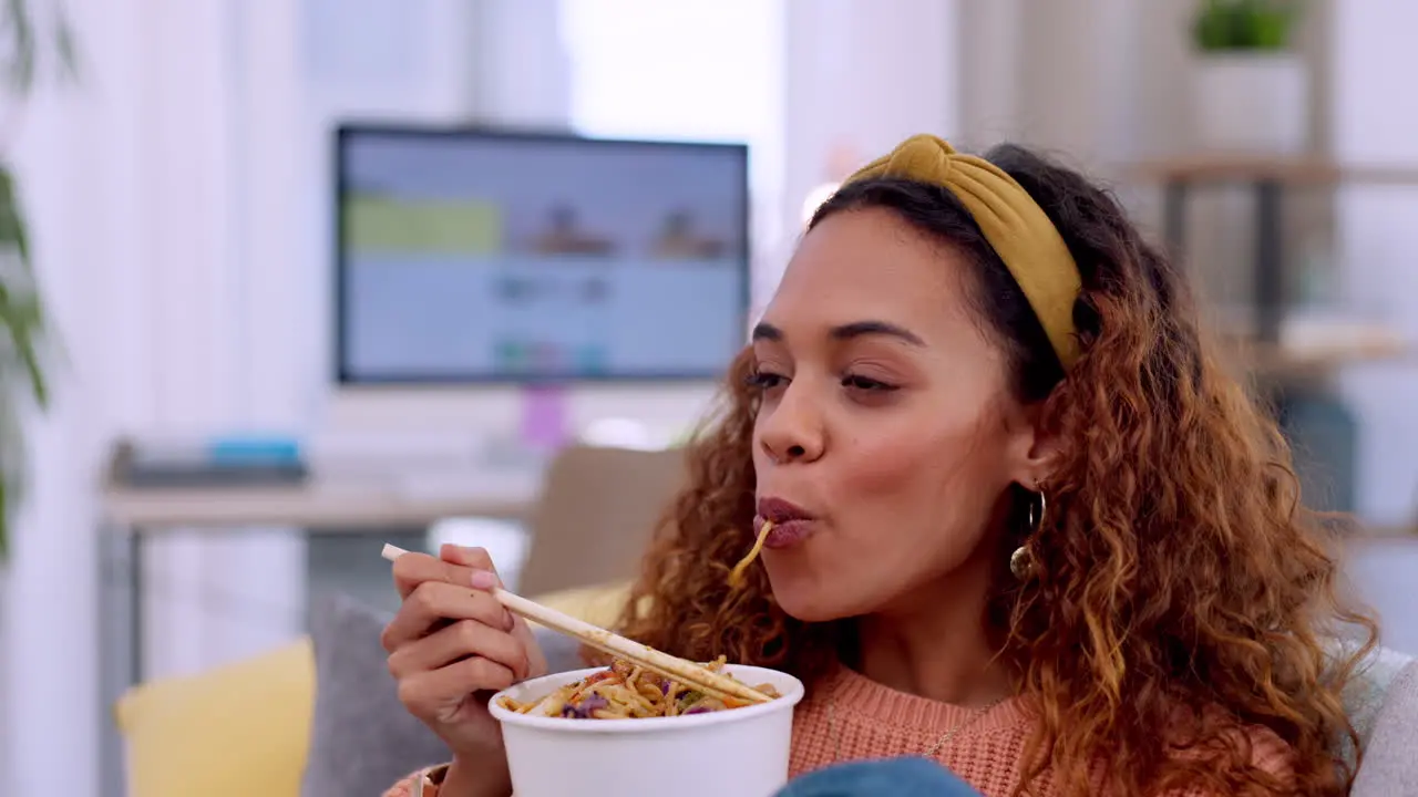 Woman eating fast food and watching tv on couch