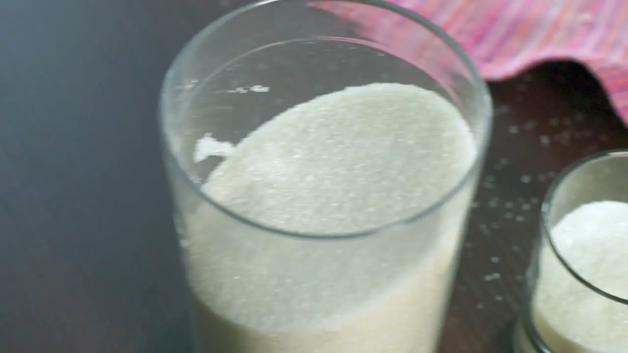 Sugar in container Sugar in glass and plastic containers Closeup