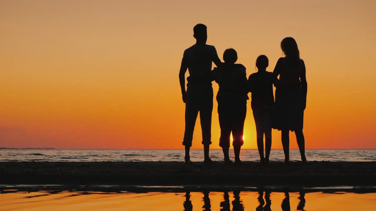 Friendly Multi-Generational Family Together Standing Next To The Sea Looking At The Horizon