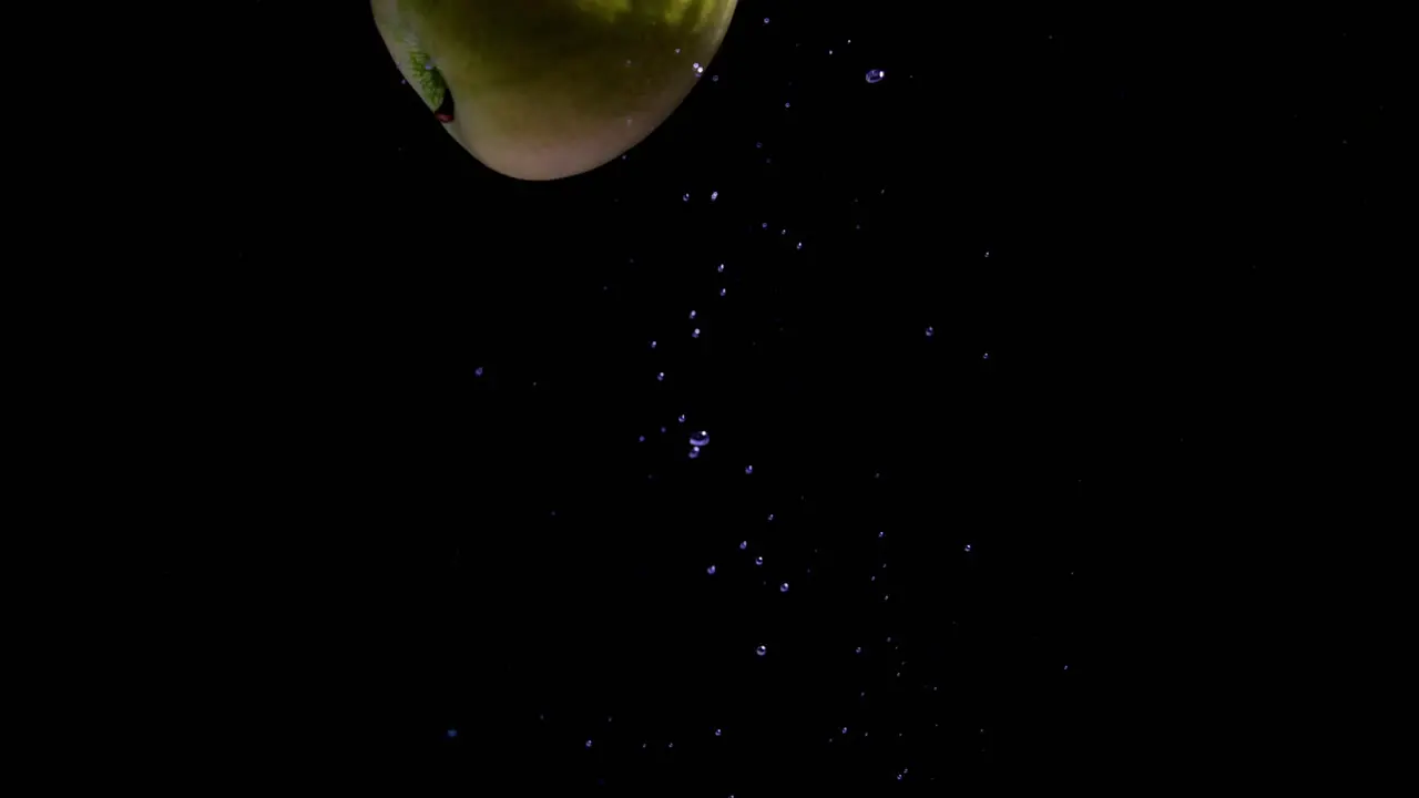 Apple diet concept Cinematic shot of green apple falling into the water background of a single fruit inside water