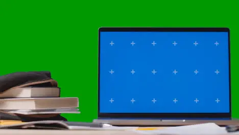 Blue Screen Laptop With Books On Table With Green Screen Background Education Concept