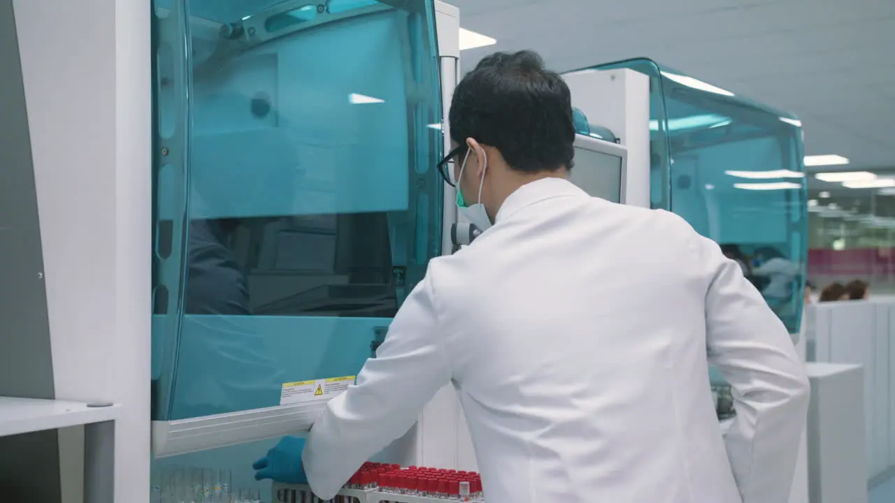 Male Pharmacist Preparing Medical Tubes