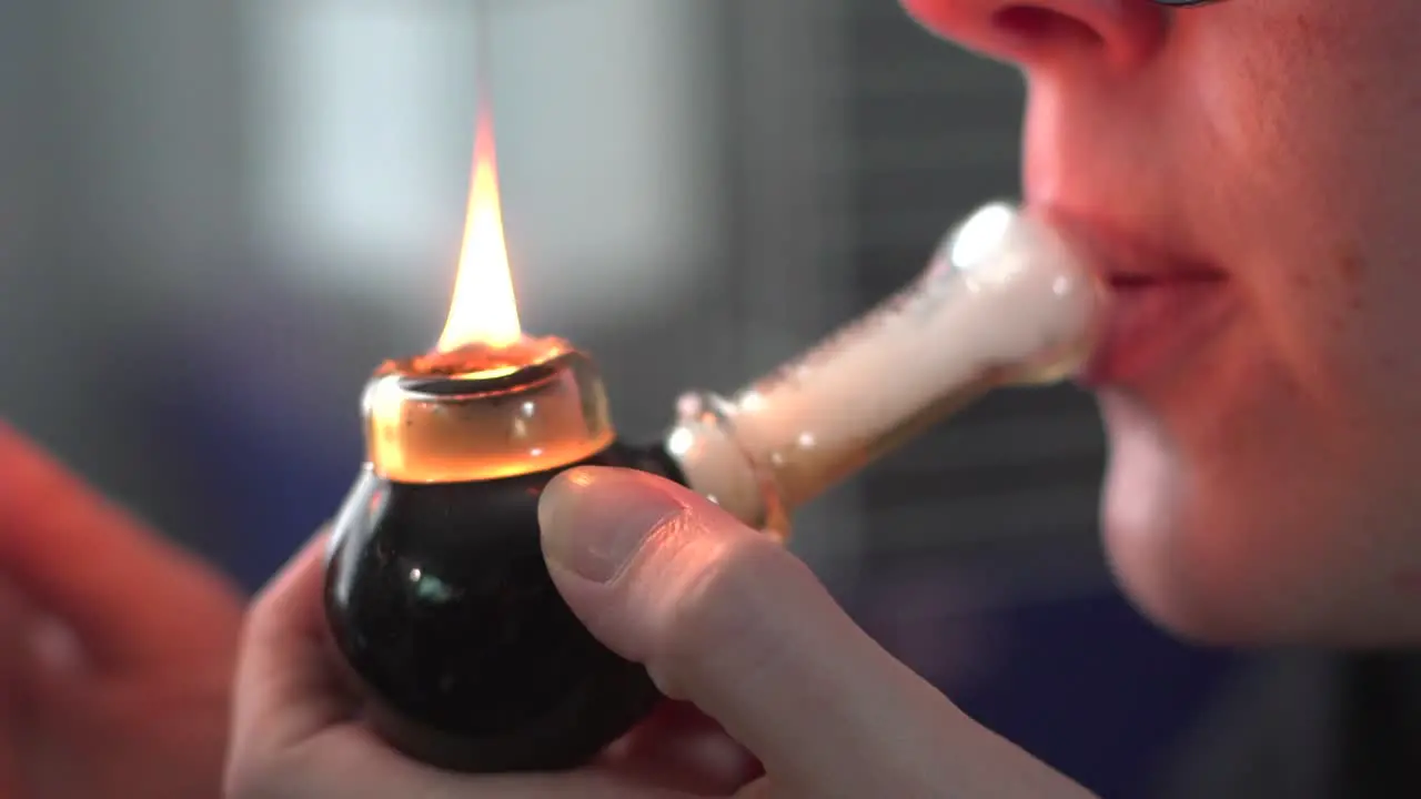 Close Up Of A Woman's Lips Inhaling Medical Marijuana Through A Smoking Pipe