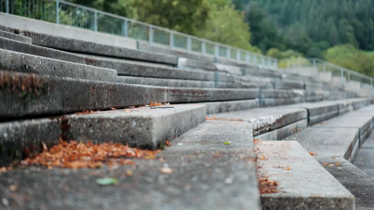 Athletic man training on the steps of an empty grandstand at the edge of a running track close-up