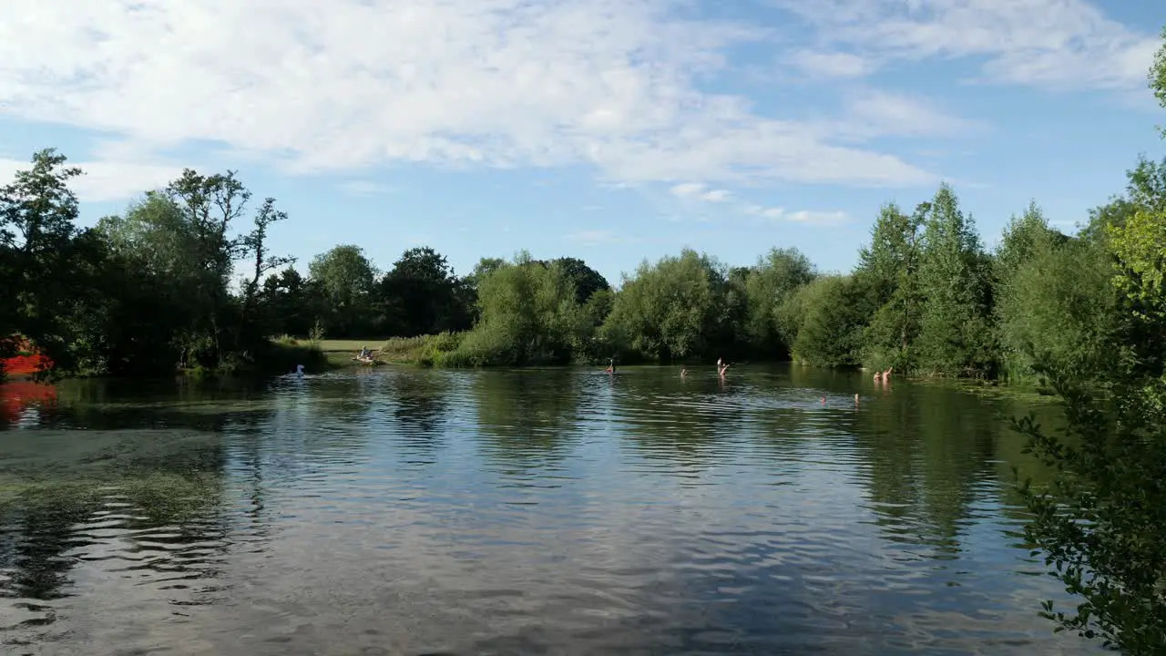 A group of people enjoying swimming in a lake on a summer day