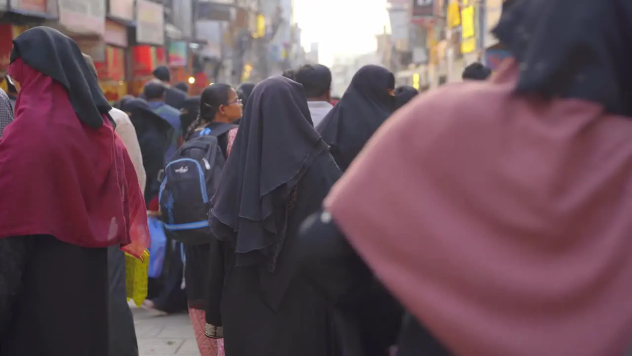 Indian Muslim women wearing traditional hijab burka and fully covered walking through the lanes of Charminar Jeweler market for shopping slow motion