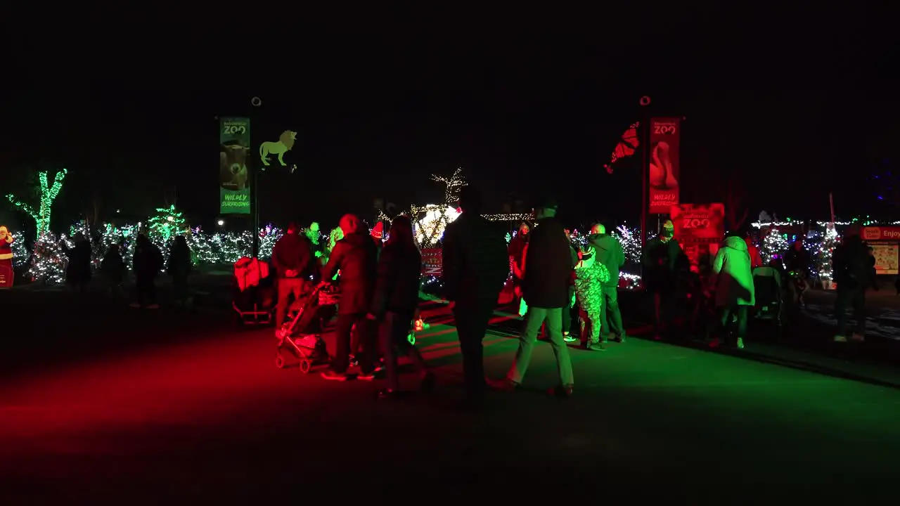 Groups Of Families Enjoying A Night At A Zoo Bright and Decorative Festive Christmas Festival