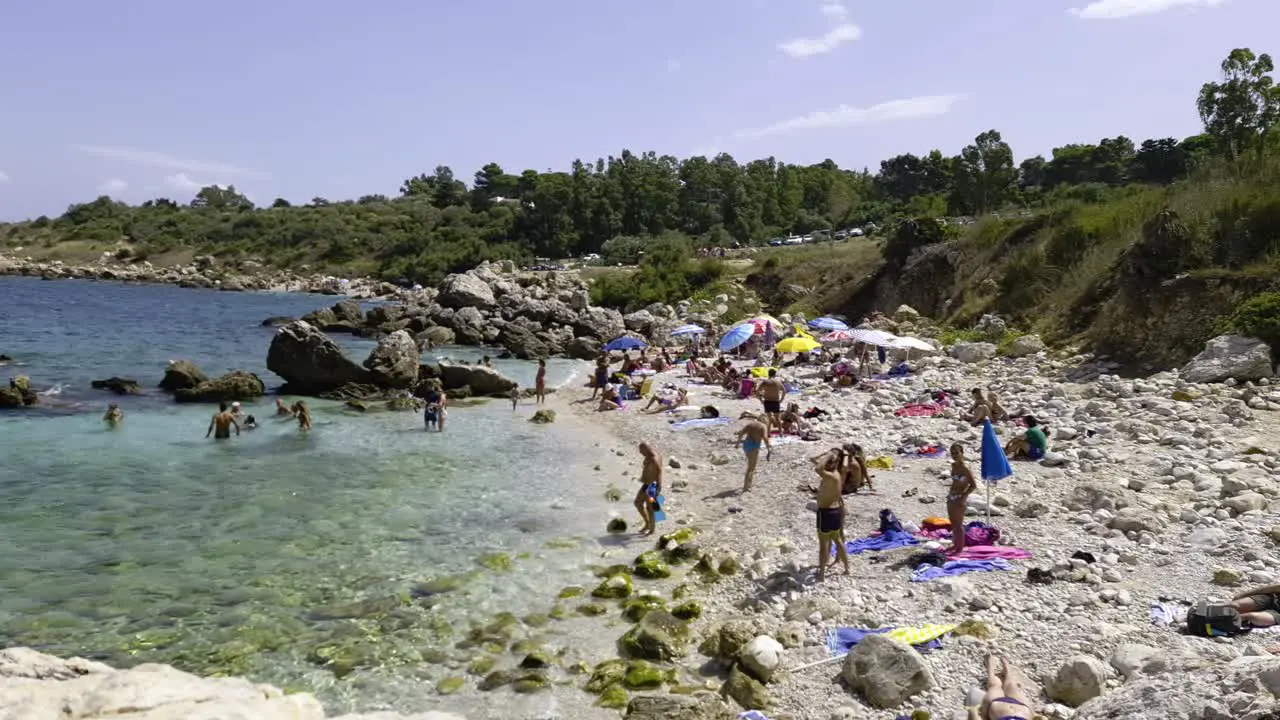 Crowd of tourists on summer holiday at Cala Mazzo di Sciacca beach in Riserva dello Zingaro Sicily in Italy