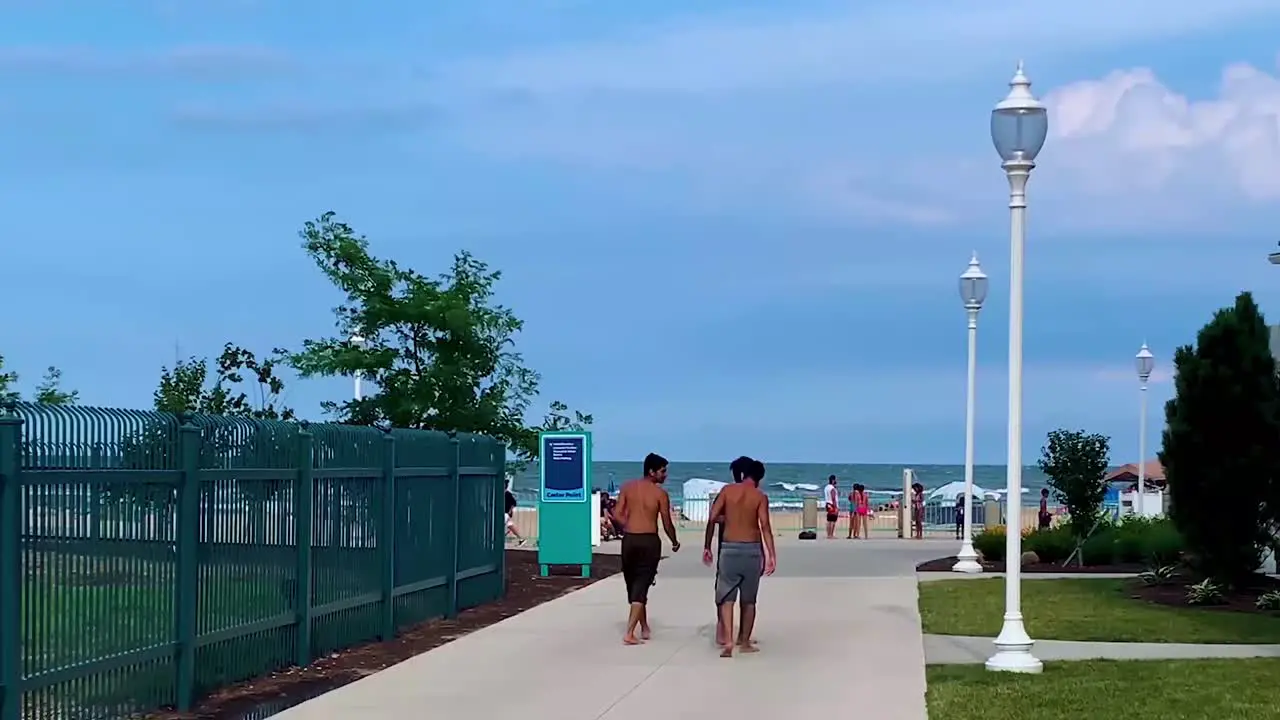 Rear view of Three asian-indian young-adullts-teenagers boy-males friends talking enjoying and heading towards to the Cedar point beach