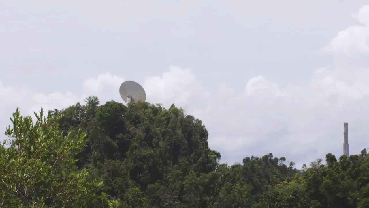 Satellite Dish Behind Dense Forest Trees In Arecibo Observatory In Arecibo Puerto Rico On A Sunny Day