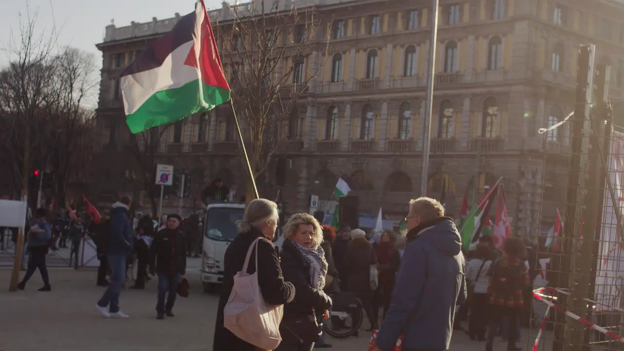 Manifestants with flag close to castello sforzesco Milan asking for freeing Palestina