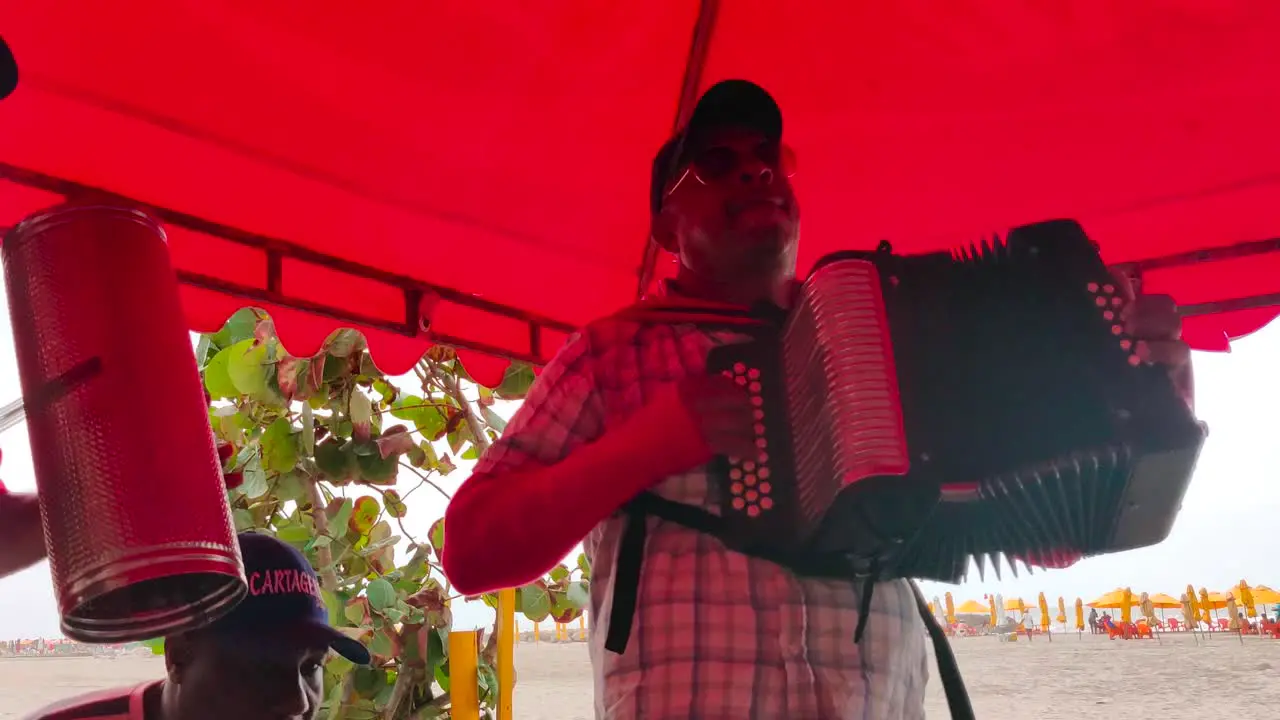 A man is playing the accordion and another is playing the Gaucharaca