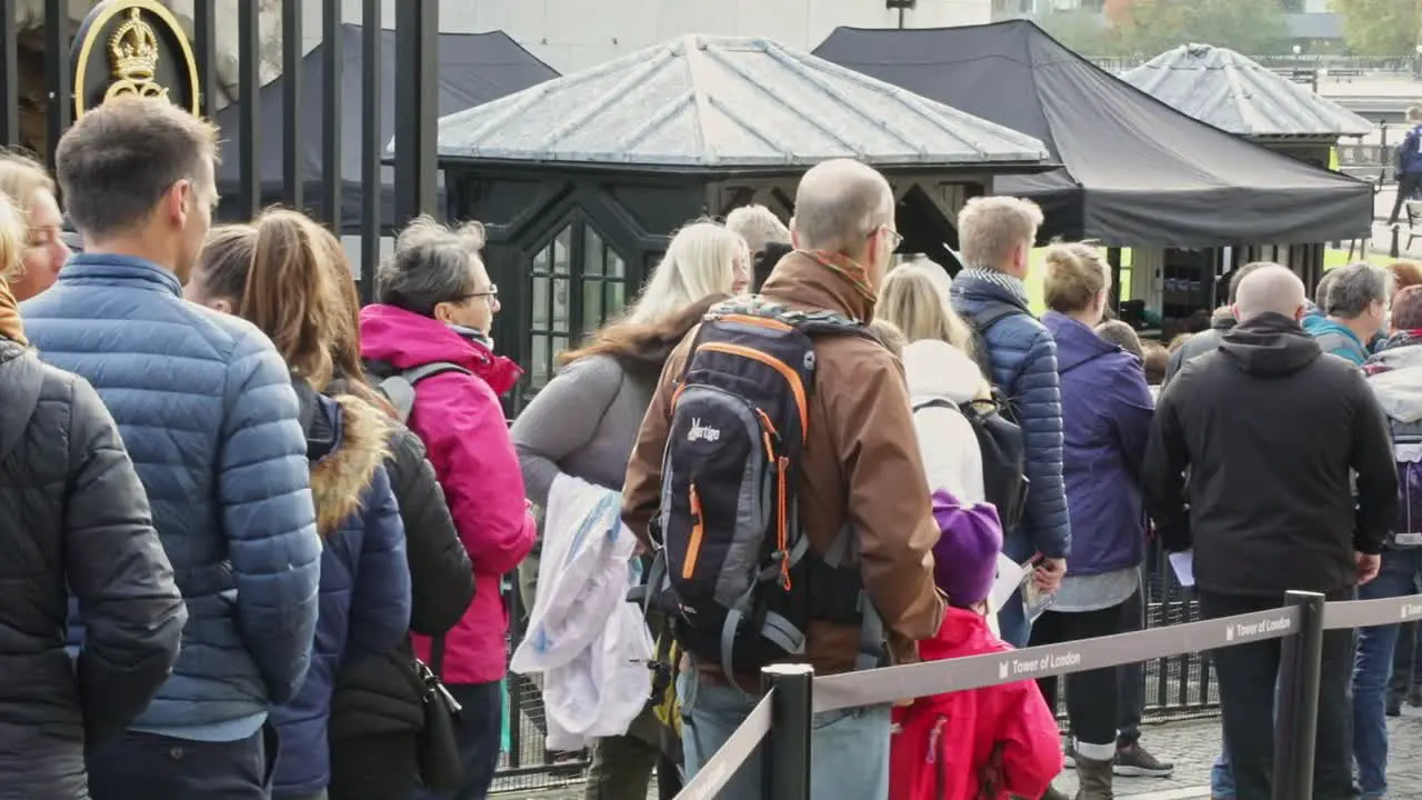 queuing up behind a crowd of people waiting to buy a ticket to enter the Tower of London England