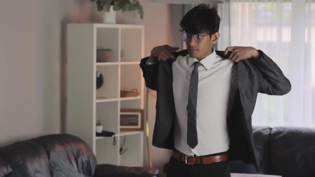 Groom Putting on Jacket Dressed in Suit Getting Ready for Wedding