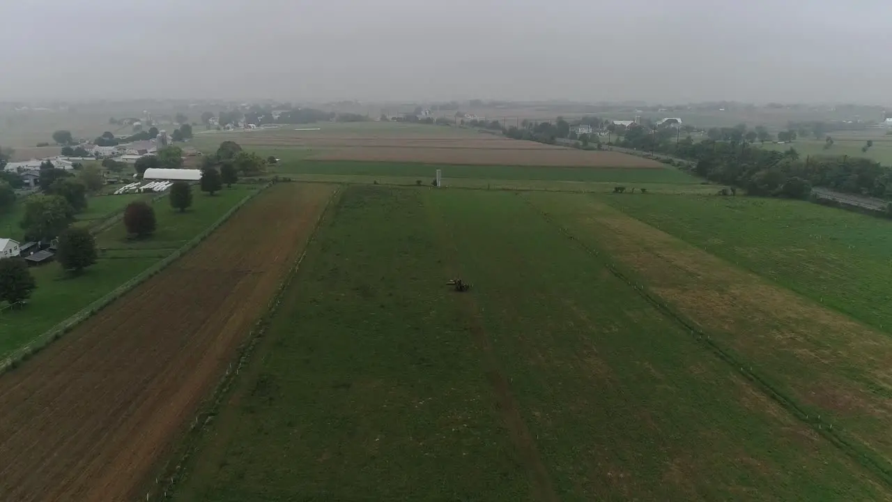 Drone Ariel View of Amish Farm Lands and Amish Farmer Harvesting in Fog