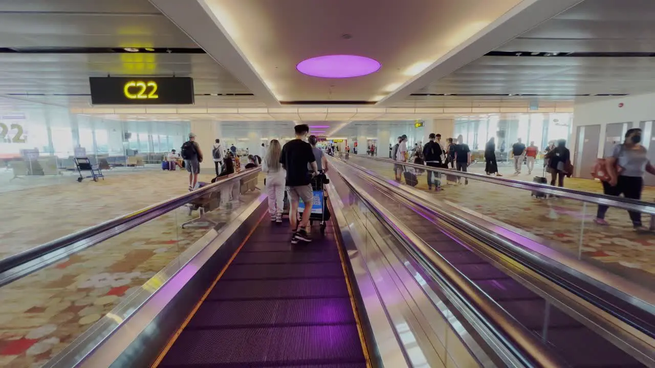 Shot while on horizontal escalator device with passengers with luggage along Hydrabad airport hall in India at daytime